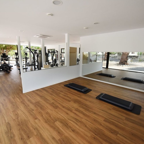 Moderner Hotel-Fitnessraum mit Holzboden & Geräten im Impressive Zocos Lanzarote.