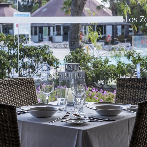 Gedeckter Esstisch mit Poolblick im beeindruckenden Los Zocos Lanzarote Club Resort.
