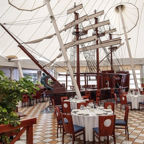 Beeindruckendes Zocos Lanzarote Restaurant mit großem Segelschiffmodell und eleganten Tischen unter heller Überdachung.