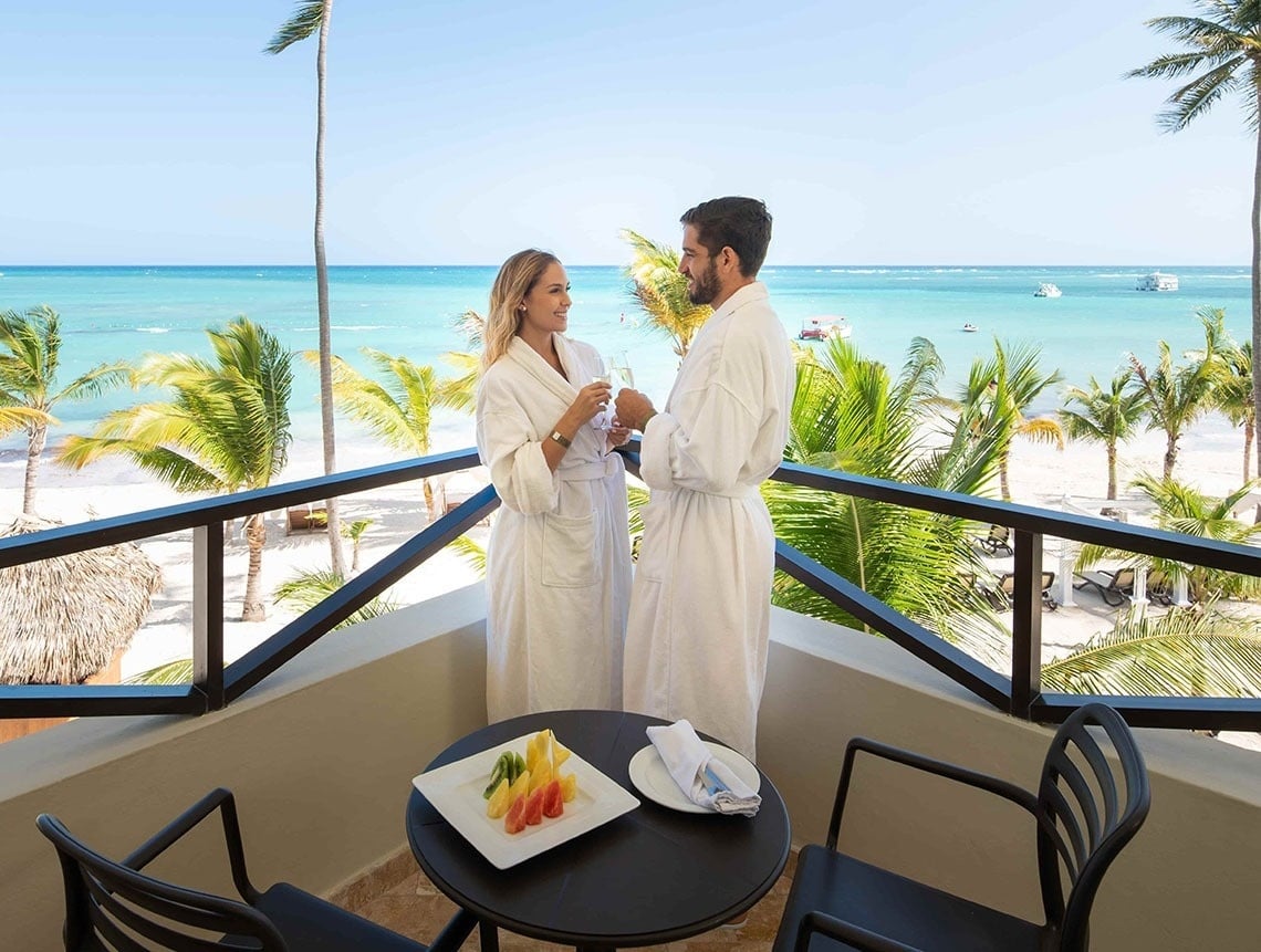 deux hommes jouent au golf sur un terrain avec des montagnes enneigées en arrière-plan