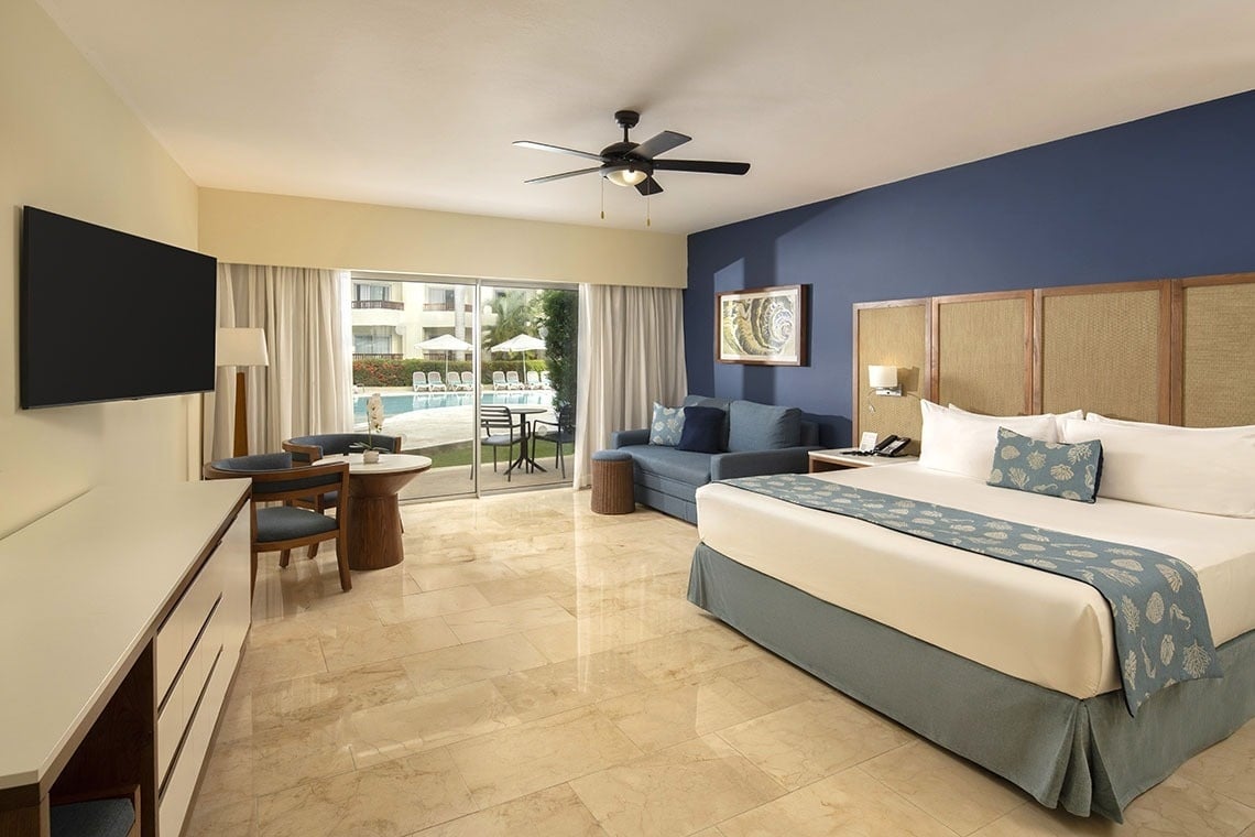 una habitación con una cama y una silla con vista al océano