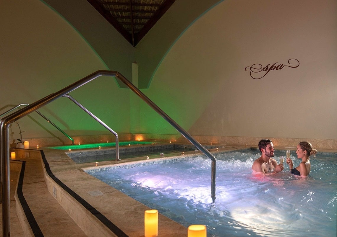 ein Mann und eine Frau spielen mit einem Volleyball am Strand