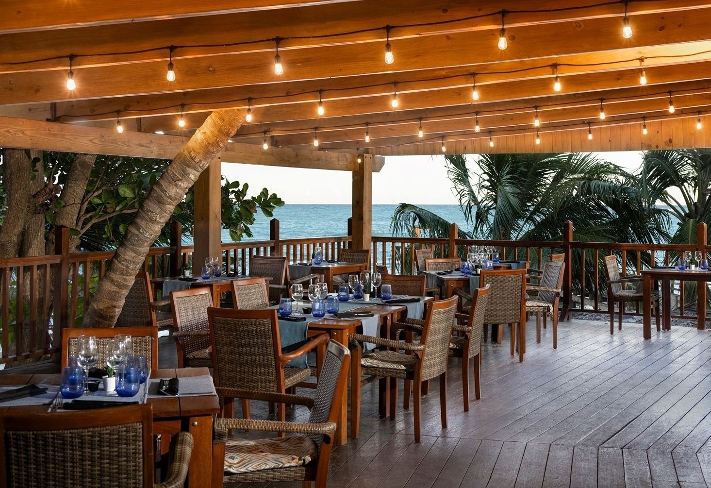 Salle à manger Impressive Resorts & Spas avec vue sur mer et végétation.