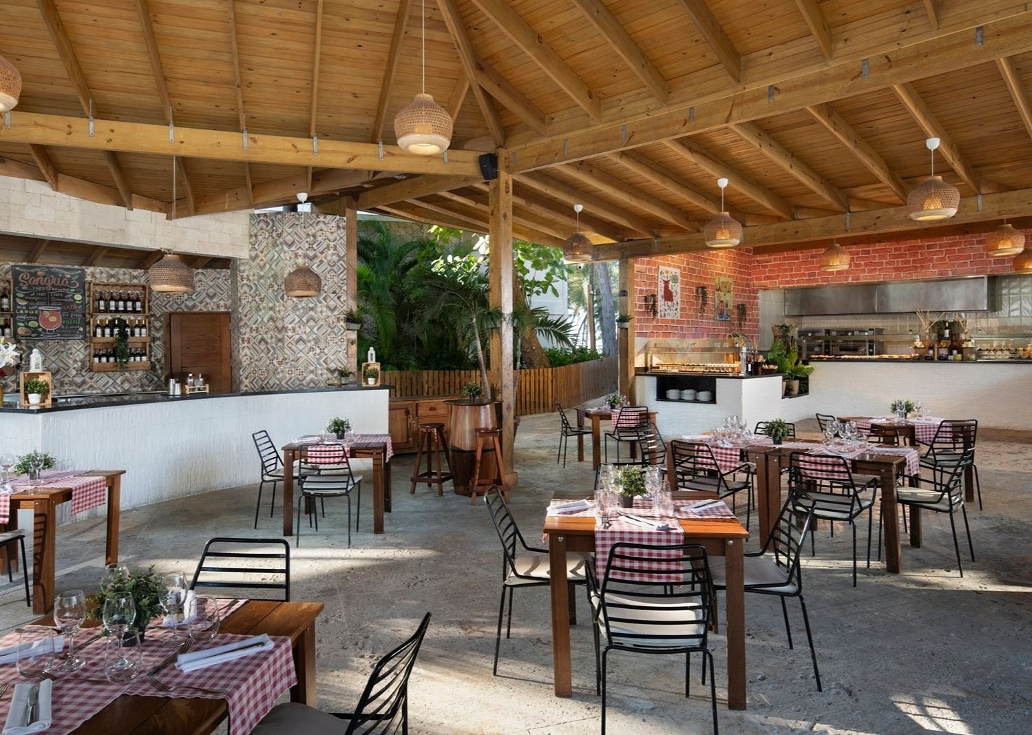 Bar et restaurant extérieur avec tables en bois chez Impressive Resorts & Spas.