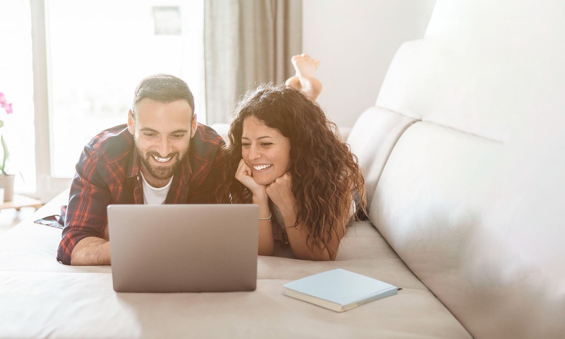 a man and a woman are looking at a laptop together