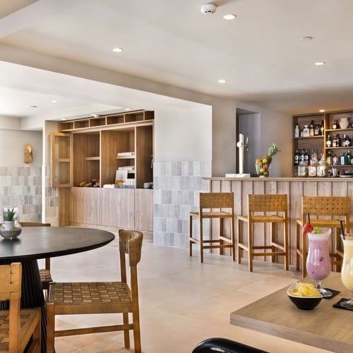 un bar avec une table et des chaises et des boissons sur la table