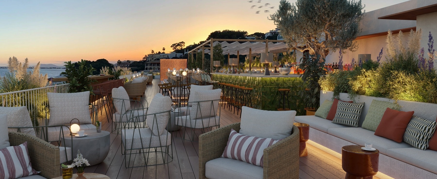 una terraza con muchos muebles y una barra al atardecer