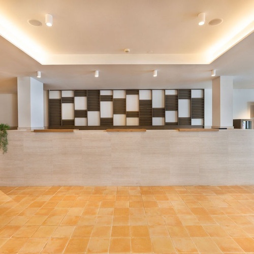 a reception area with a tiled floor and a tv on the wall