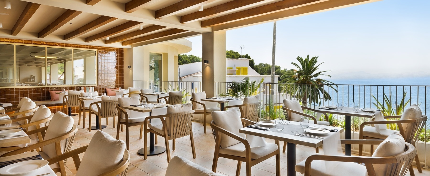 una terraza con muchos muebles y una barra al atardecer