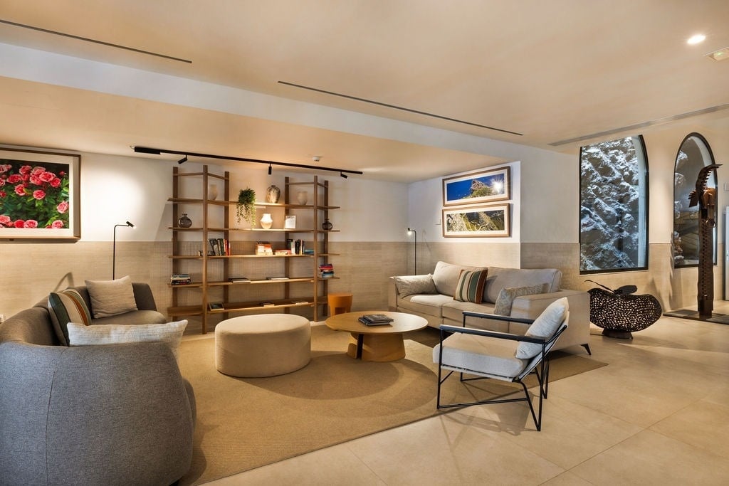 un salon avec des canapés et des chaises et une étagère en bois