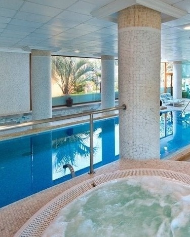 une piscine intérieure avec un jacuzzi à côté d' elle