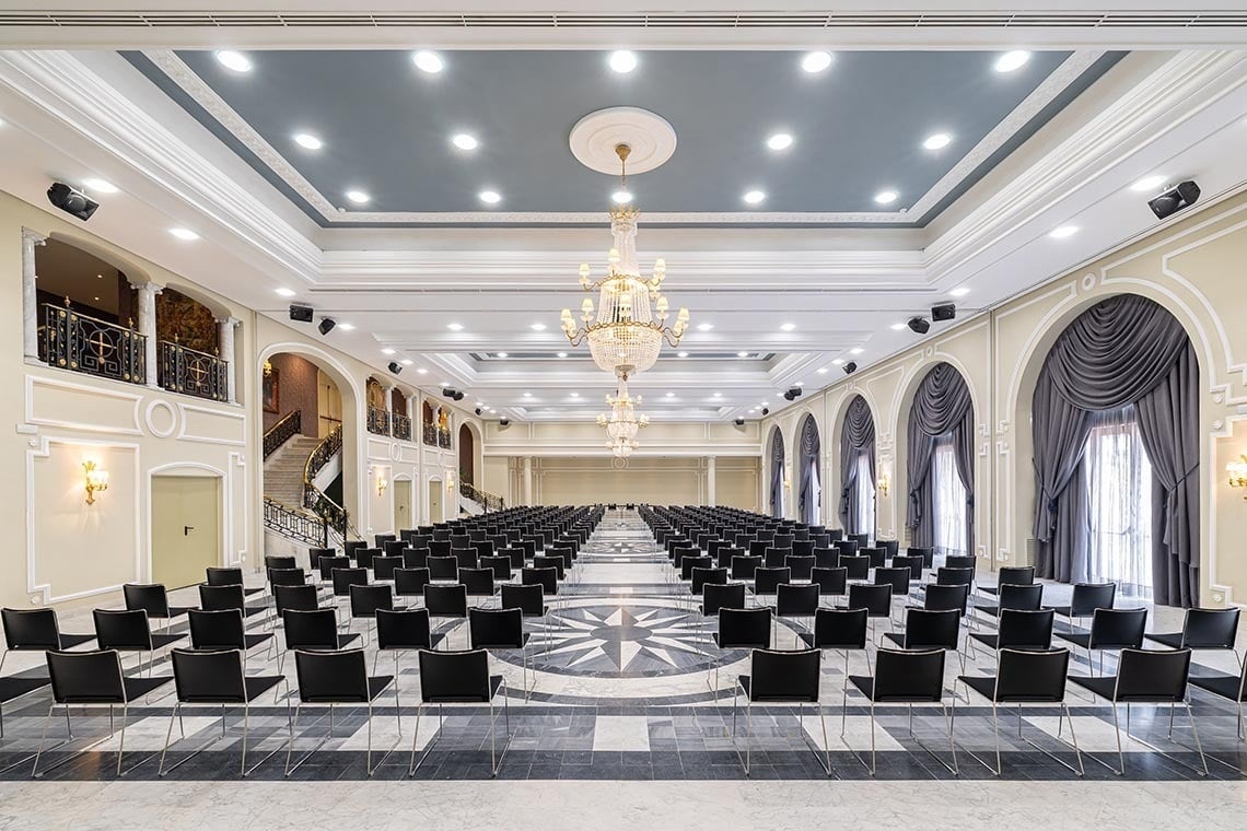 eine Reihe von blauen Tischen und Stühlen in einem großen Raum