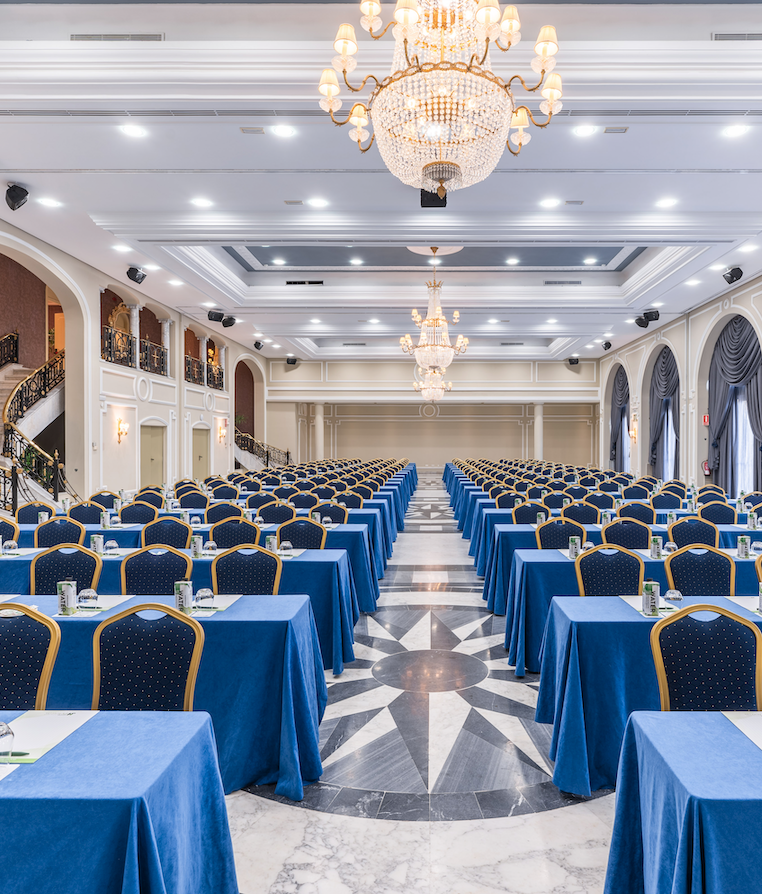 un gran salón con muchas mesas y sillas azules