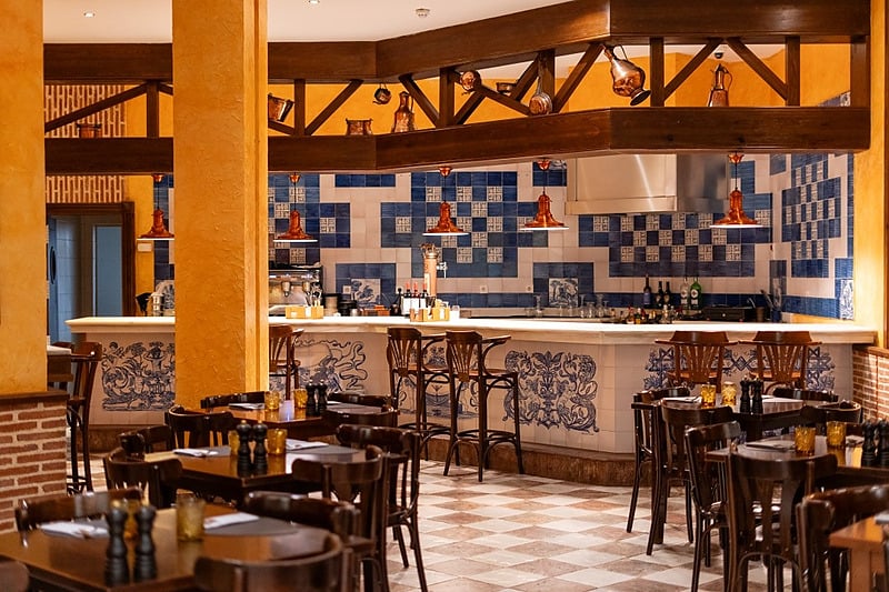 Intérieur de l'hôtel IPV: Palace : tables, chaises et coin bar.