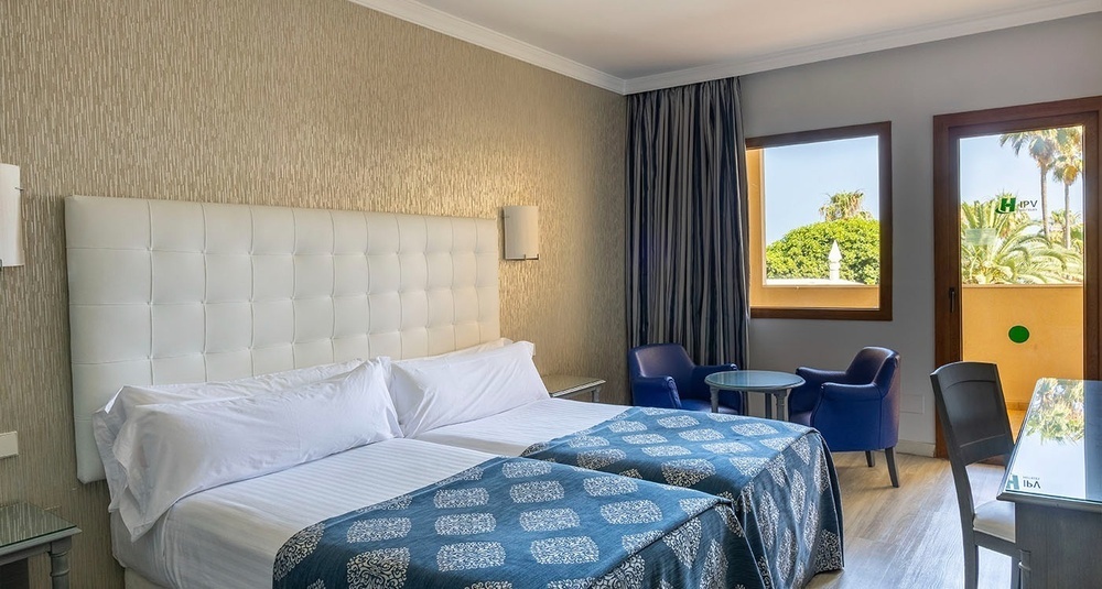 a hotel room with two beds and a table