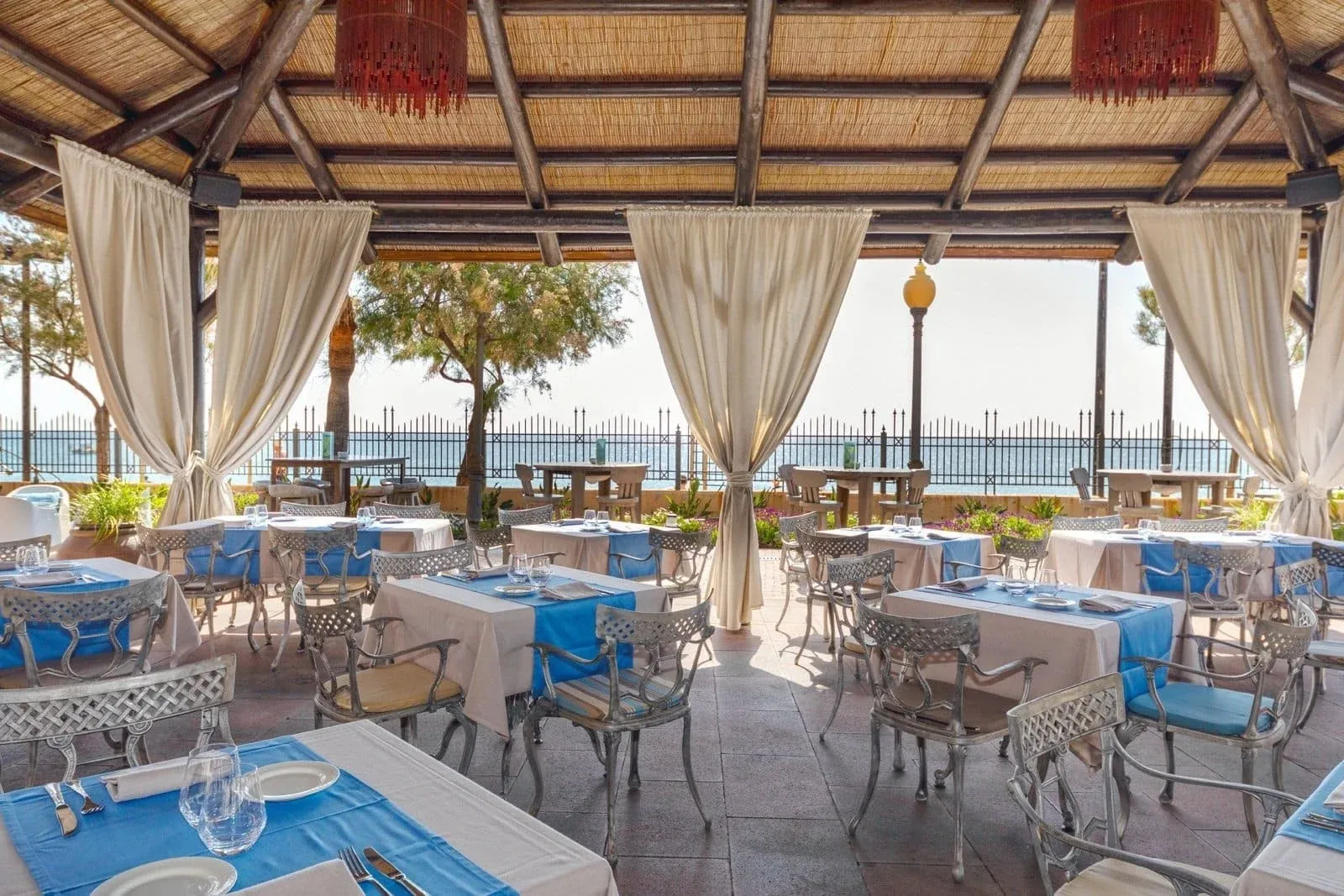 IPV: Palace Terrasse mit Tischen und Meerblick.