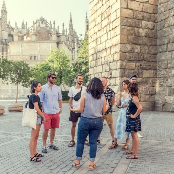 un grupo de personas de pie frente a una pared de ladrillo