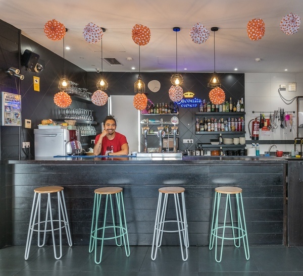 a man sits at a desk in front of a sign that says sevilla