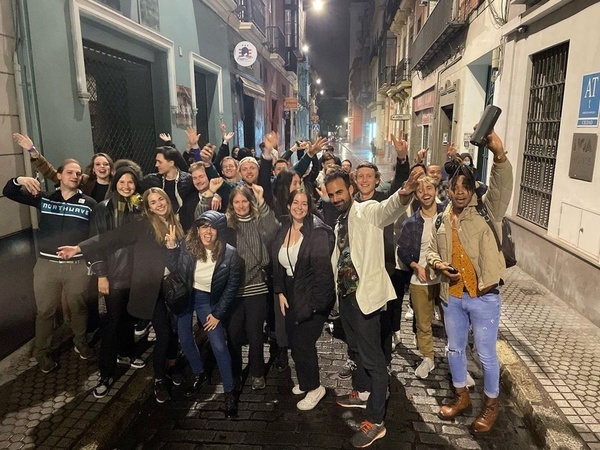 un grupo de personas están posando para una foto en una calle de la ciudad