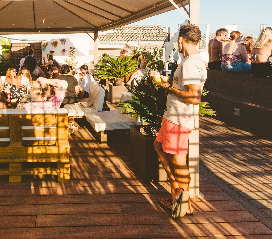 a man standing on a wooden deck holding a drink