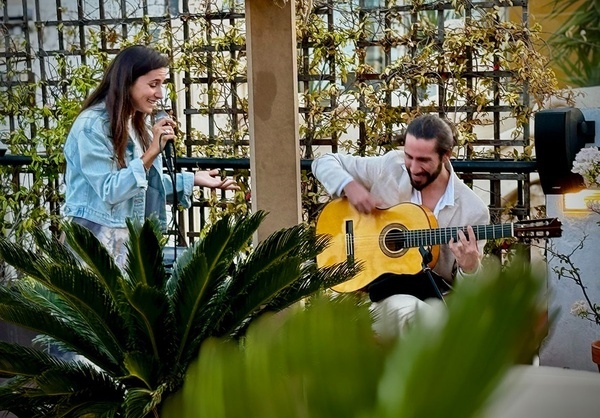 un hombre toca la guitarra mientras una mujer canta en un micrófono