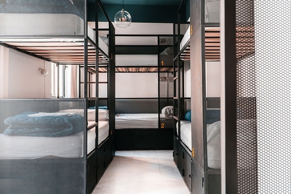 un grupo de personas se paran frente a un cartel que dice casis hostels backpackers palace