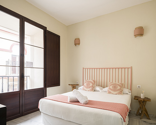 Habitación con dos camas, almohadas a rayas y toallas enrolladas. JOY: Corporativa.
