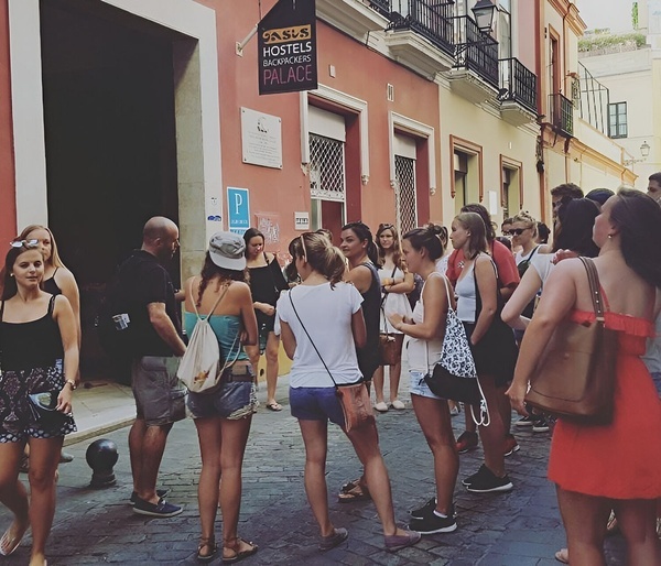 a group of people standing outside a hostel called oasis backpackers palace