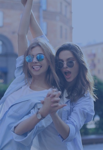 two women wearing sunglasses are holding each other up in the air