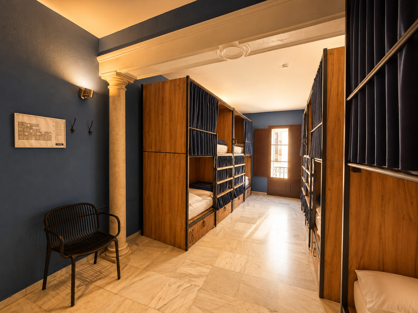 Cama en dormitorio compartido de JOY: Plaza de Armas, con taquillas numeradas.
