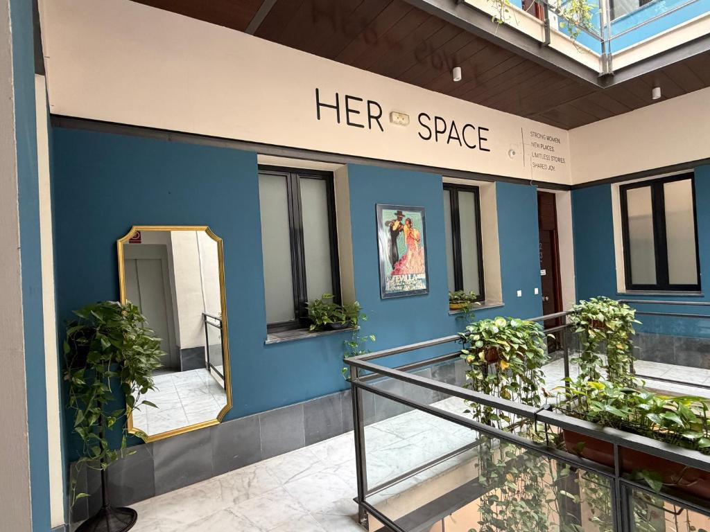 Her Space JOY: Setas Coworking: A stylish, plant-filled courtyard with unique artwork and mirrors.