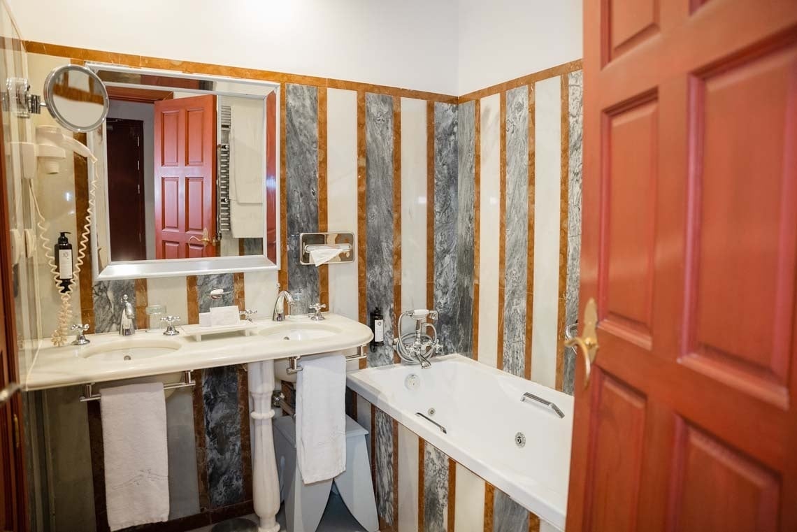 Luxurious bathroom with double sinks and bathtub at Juderia: Cordoba hotel.