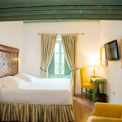 Cozy Juderia: Cordoba hotel room with a plush bed, vintage desk, and ornate decor.