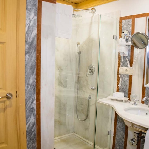 Luxurious Juderia: Cordoba bathroom with marble shower, vanity, and hairdryer.