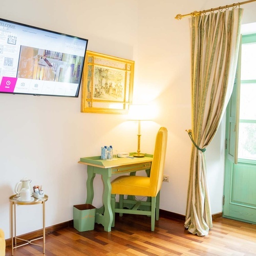 Charming desk and chair in a Juderia: Cordoba hotel room, with TV and window.