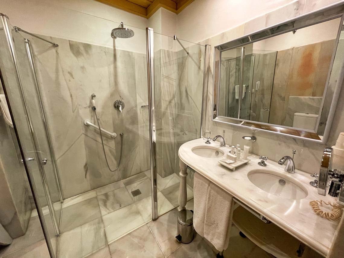 Elegant bathroom in Juderia: Cordoba with double vanity, marble, and glass shower.