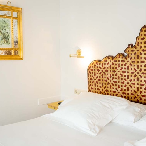 Elegant bedroom with intricate gold headboard, Juderia: Cordoba.