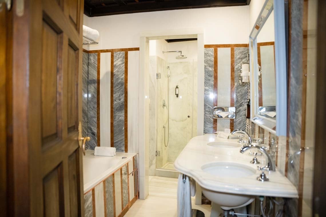 Luxurious bathroom with double sinks, bathtub, and shower in Juderia: Cordoba hotel.
