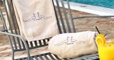a striped towel is rolled up on a chair near a pool