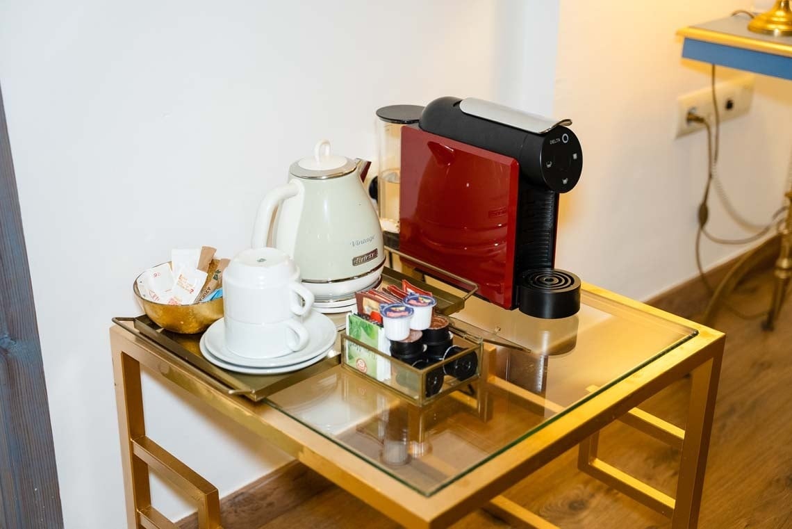 Delightful coffee station in Juderia: Cordoba with a kettle, coffee machine, and cups.