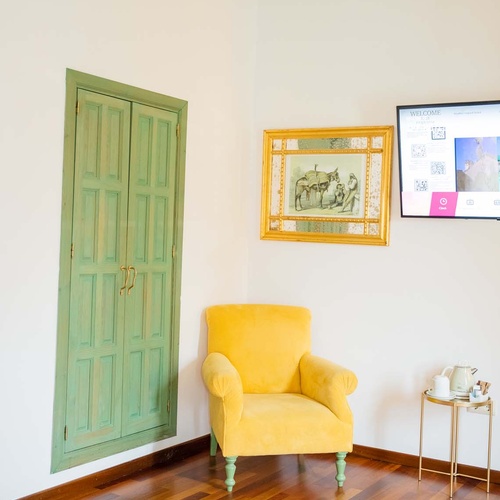 Yellow armchair and green doors in a Juderia: Cordoba hotel room.