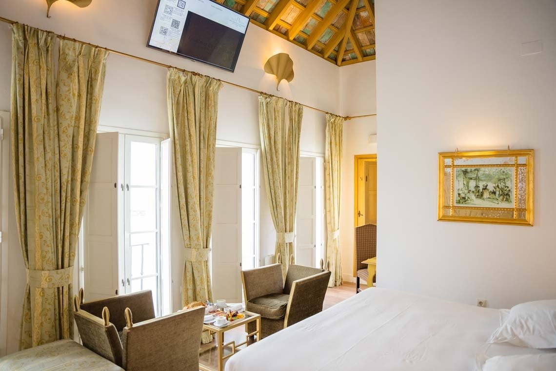 Elegant hotel room with ornate curtains & view of Juderia: Cordoba.