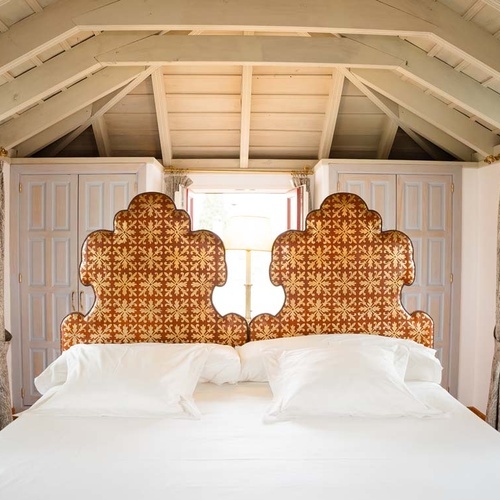 Luxurious Juderia: Cordoba bedroom with ornate headboards and vaulted ceiling.