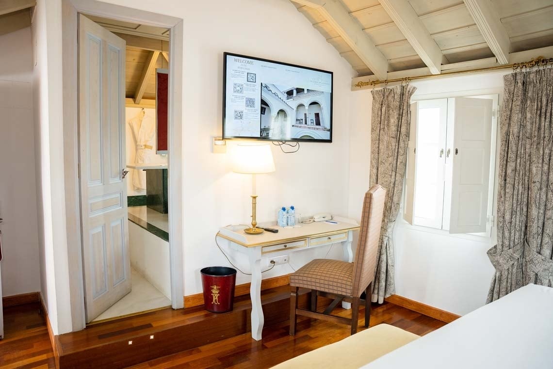 Modern room with desk, TV, and view of the Juderia: Cordoba hotel.