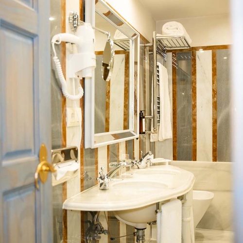 Luxury bathroom with dual sinks and striped marble, near Juderia: Cordoba.