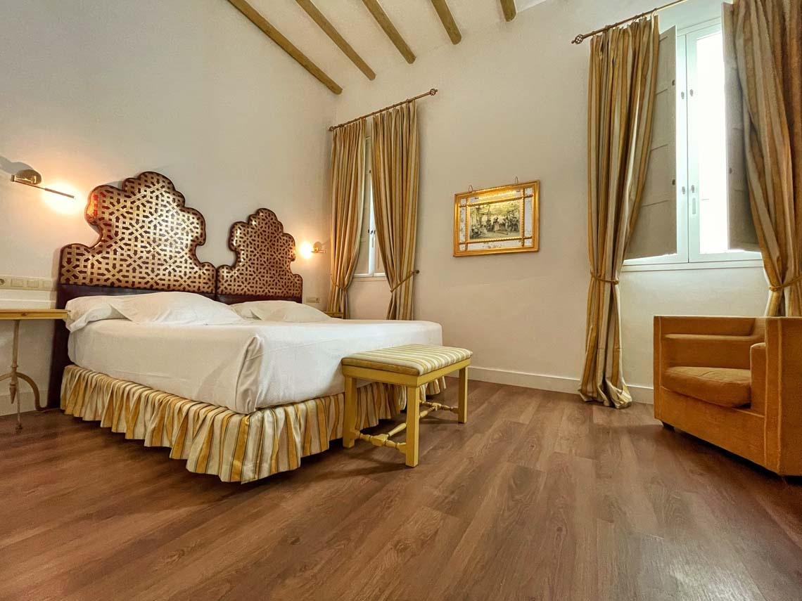 Elegant bedroom with ornate headboard in Juderia: Cordoba.