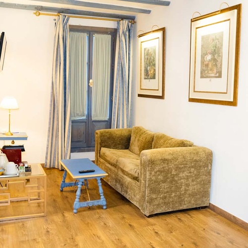 Cozy living area in Juderia: Cordoba with a sofa, coffee table, and decorative art.