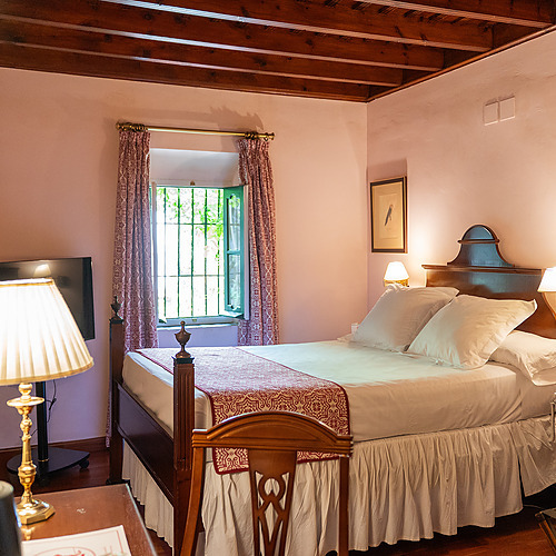 Chambre d'hôtel confortable avec lit douillet, lampes de chevet et Juderia: Sevilla.