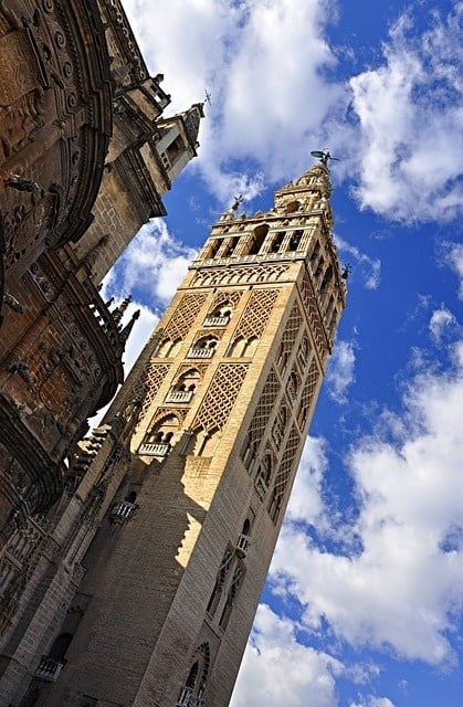 una torre muy alta con un cielo azul y nubes en el fondo