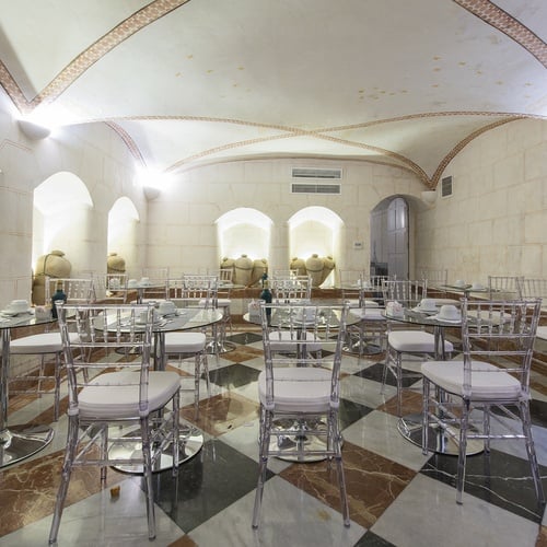 Elegant dining room in Juderia: Sevilla with crystal chairs & historic jars.